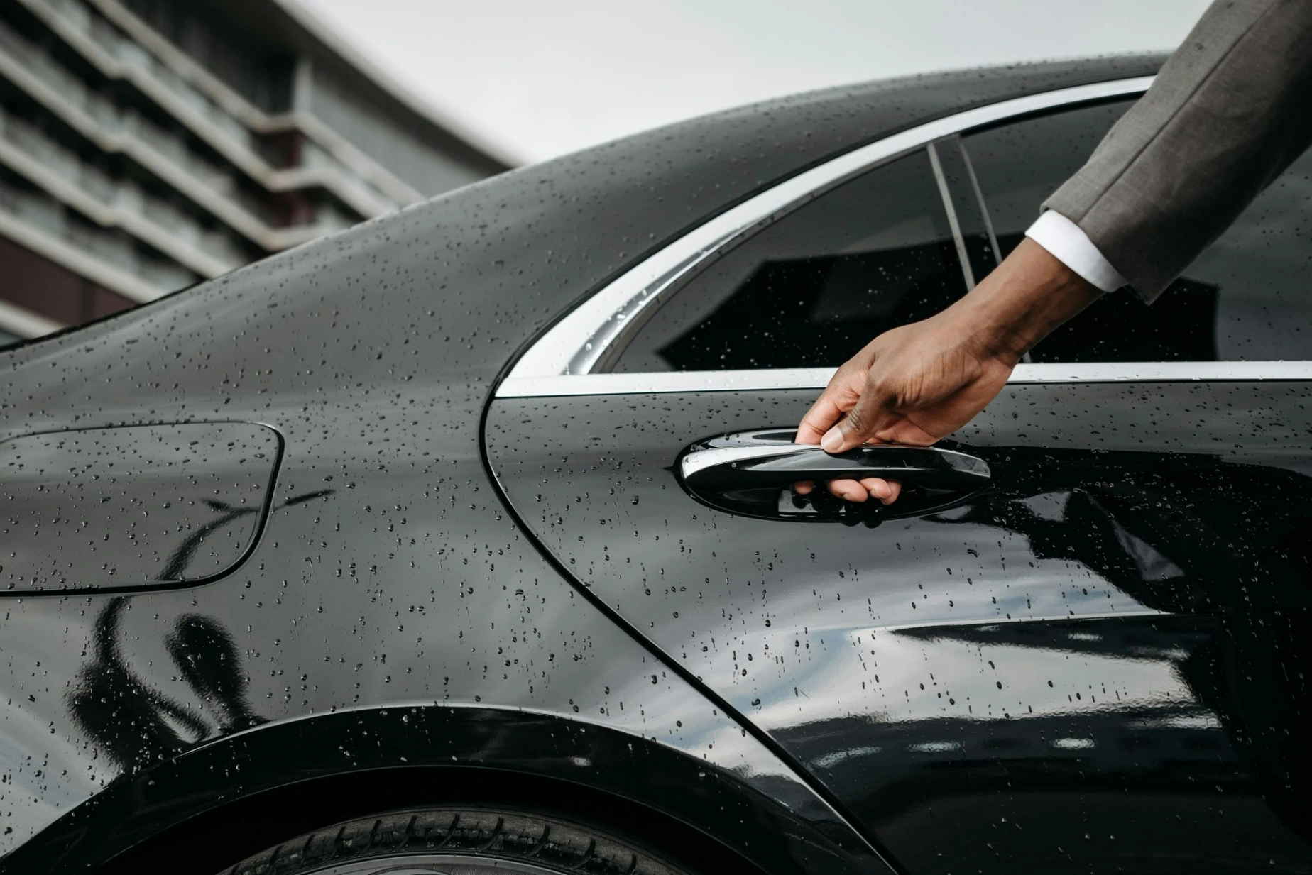 Person Holding a Car Door Handle for Private Transfer